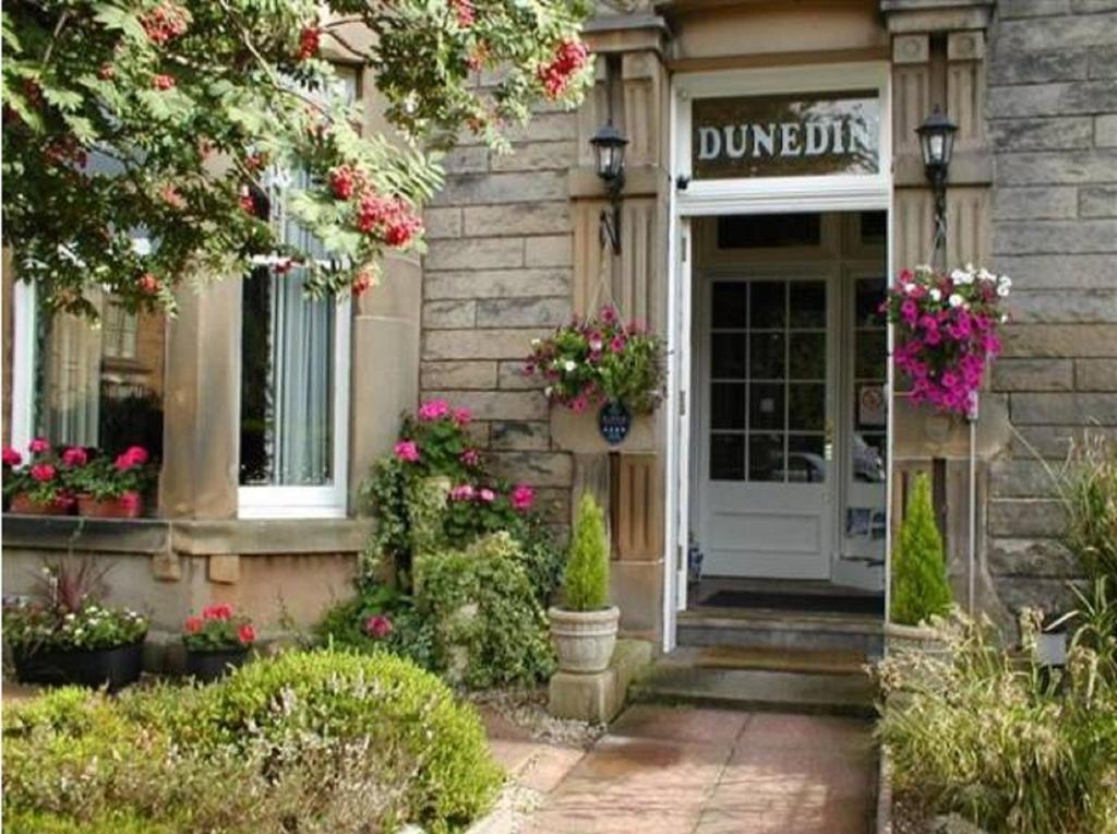 une porte d'entrée d'un bâtiment avec des fleurs. dans l'établissement A two bedroom apartment - Victorian Villa at 8 Priestfield Road, à Édimbourg