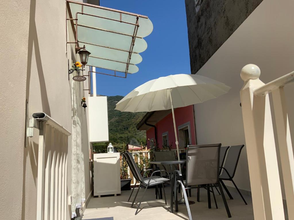 um pátio com uma mesa e um guarda-chuva em Casa La Wanda In Camaiore Toscana Terrazza em Camaiore