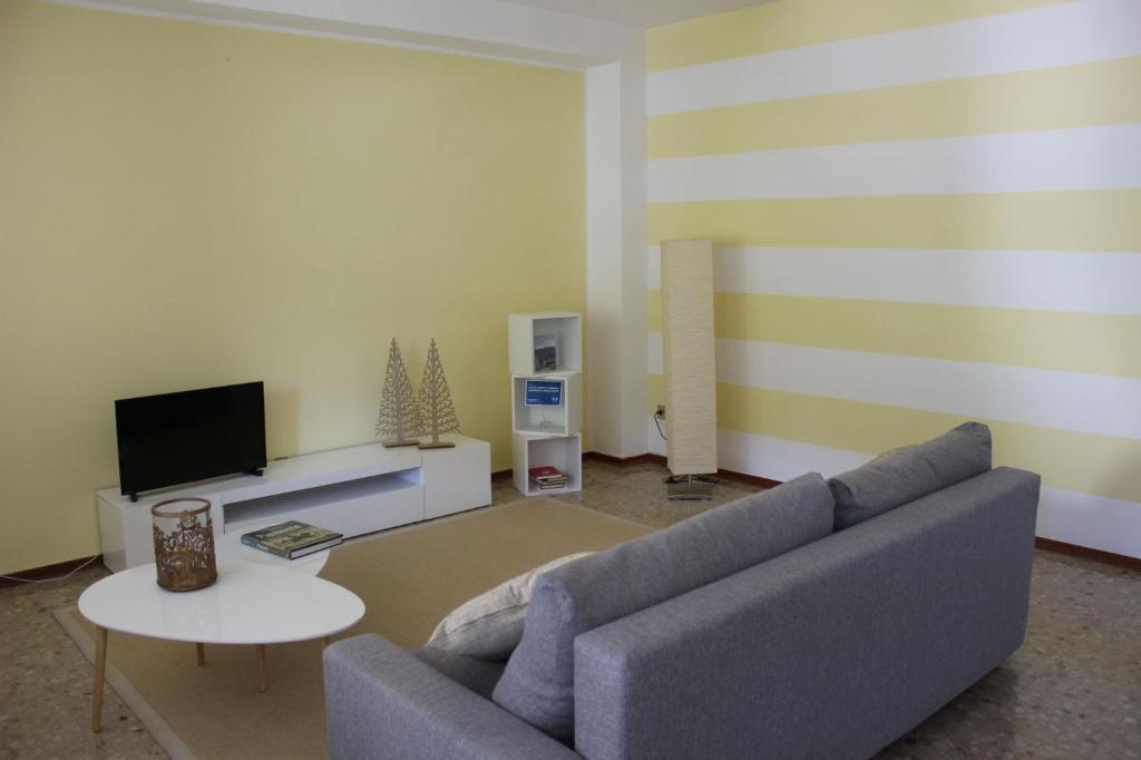 a living room with a couch and a tv at APPARTAMENTO AMPIO E LUMINOSO LAGO D'ORTA in San Maurizio dʼOpaglio