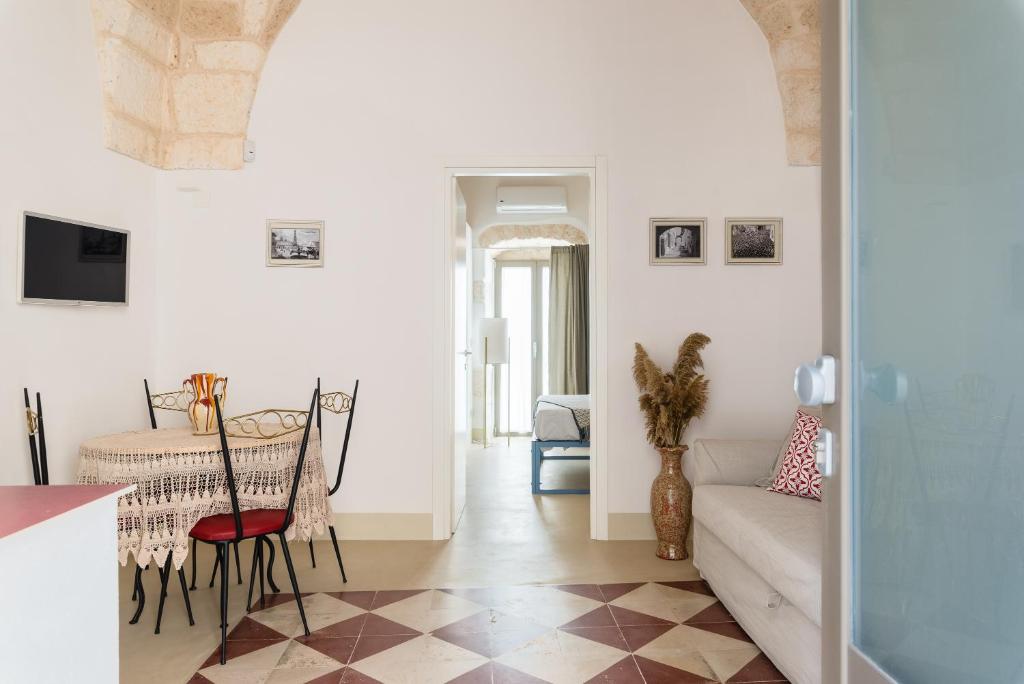 sala de estar con mesa y sofá en Cementine Traditional Suites by Wonderful Italy, en Ostuni