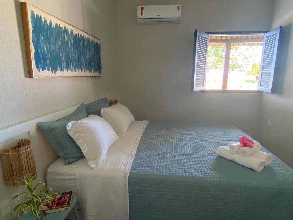 a bedroom with a bed with a towel on it at Casa beira mar, 4 quartos - Sanzé - Maragogi/AL in São José da Coroa Grande