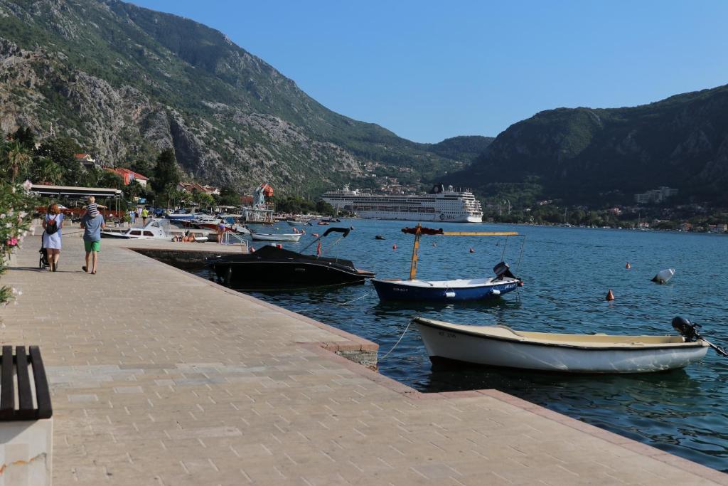 a group of people walking on a dock with boats in the water at Apartment Sandrita in Kotor