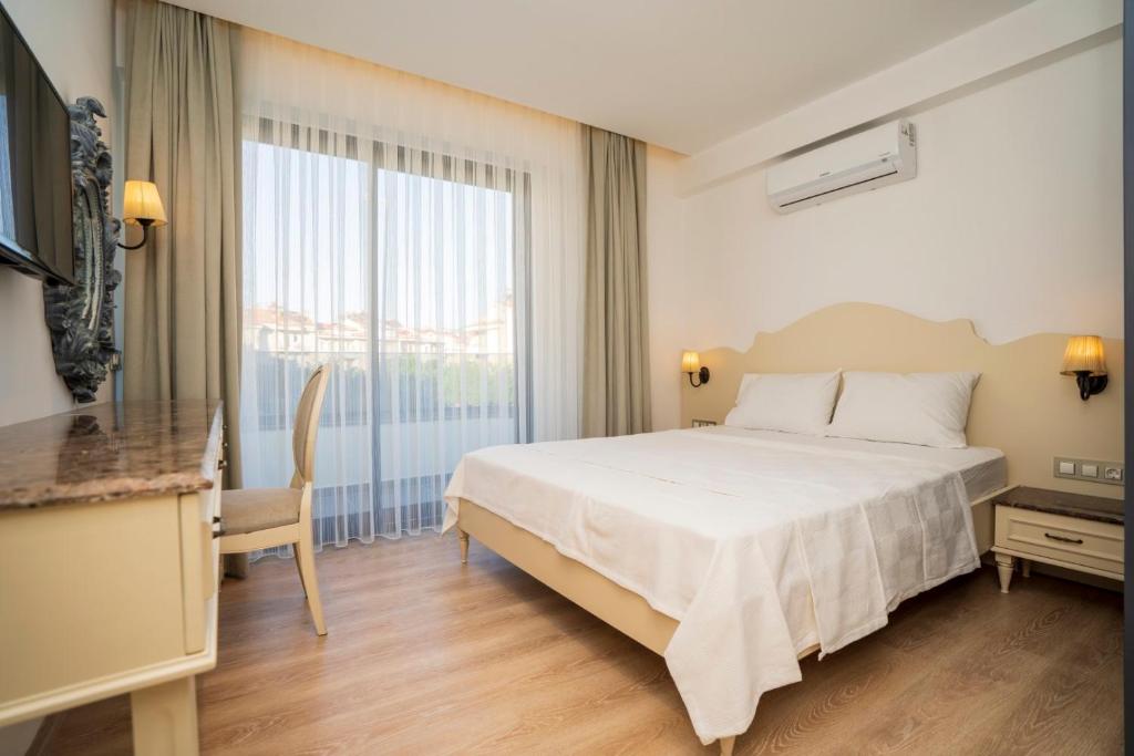 een slaapkamer met een wit bed en een groot raam bij Channel Suites in Fethiye