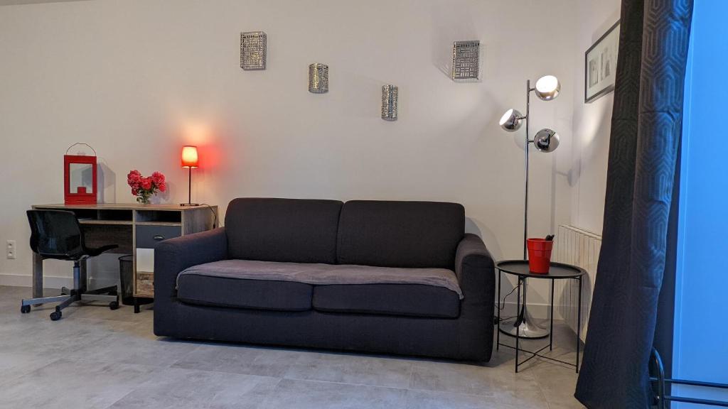 a living room with a couch and a desk at Le petit Moulin de la Motte in Bellenot-sous-Pouilly