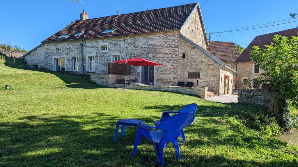 una casa con dos sillas azules delante de ella en Le petit Moulin de la Motte, en Bellenot-sous-Pouilly