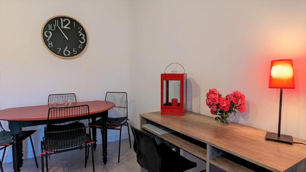 a dining room with a table and a clock on the wall at Le petit Moulin de la Motte in Bellenot-sous-Pouilly