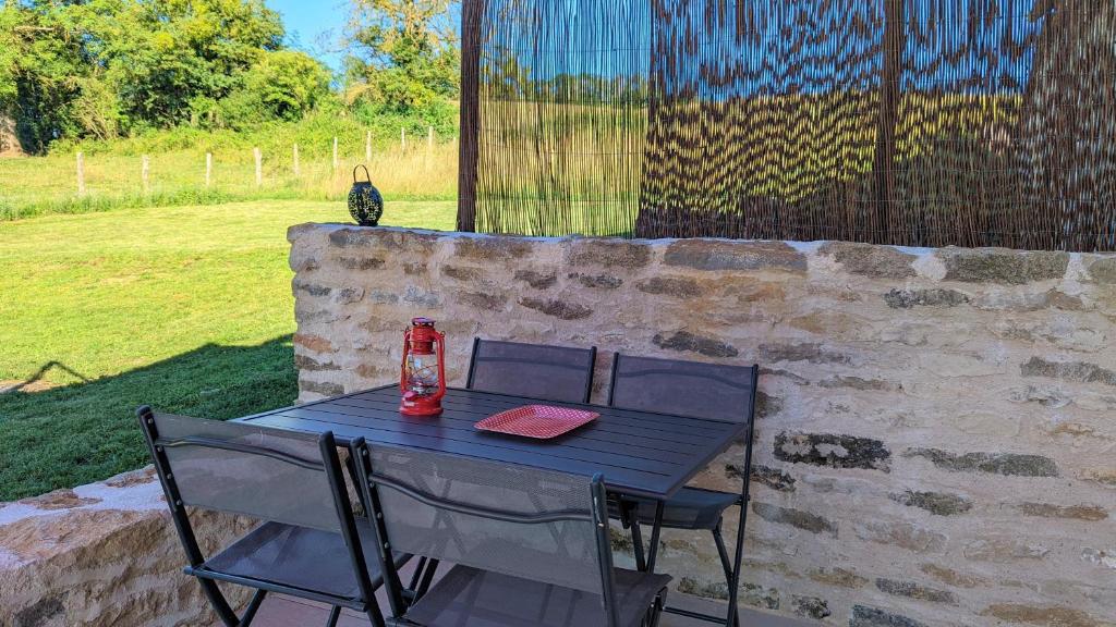 a table with two chairs and a drink on it at Le petit Moulin de la Motte in Bellenot-sous-Pouilly