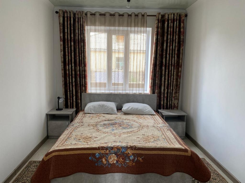 a bedroom with a bed with a large window at Guest House Baytur in Kochkor