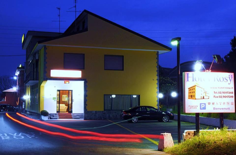 a yellow building with a sign in front of it at Hotel Rosy in Arluno