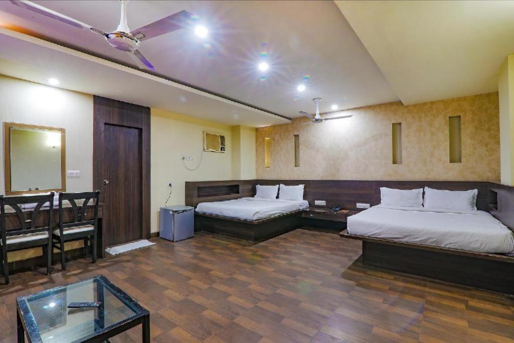 Habitación de hotel con 2 camas y mesa en SHELTER HOTEL, en Lucknow