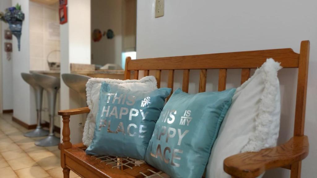 un banco de madera con 2 almohadas en Margate Happy Place, en Margate