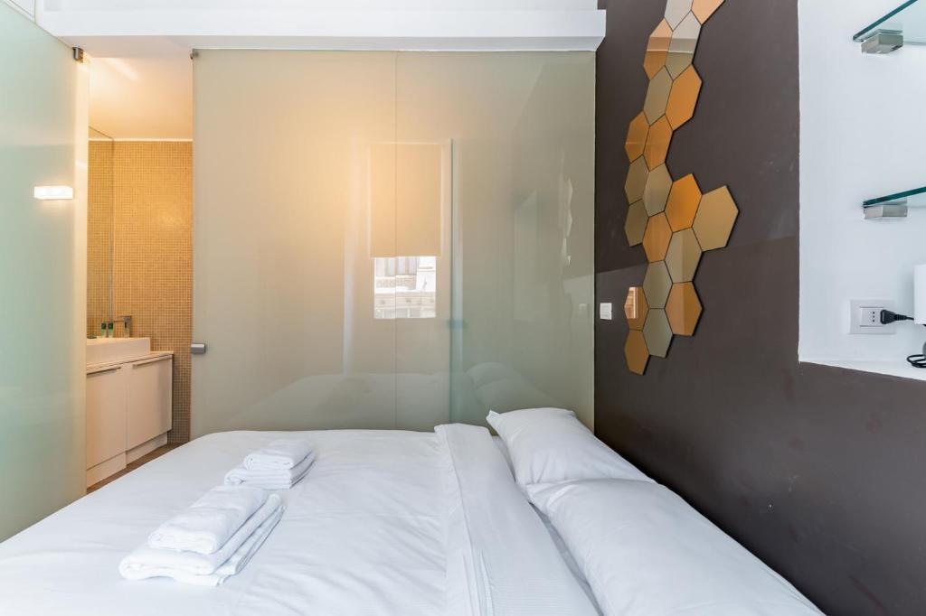 sypialnia z białym łóżkiem i ręcznikami na nim w obiekcie Amazing flat in Duomo by Easylife w Mediolanie