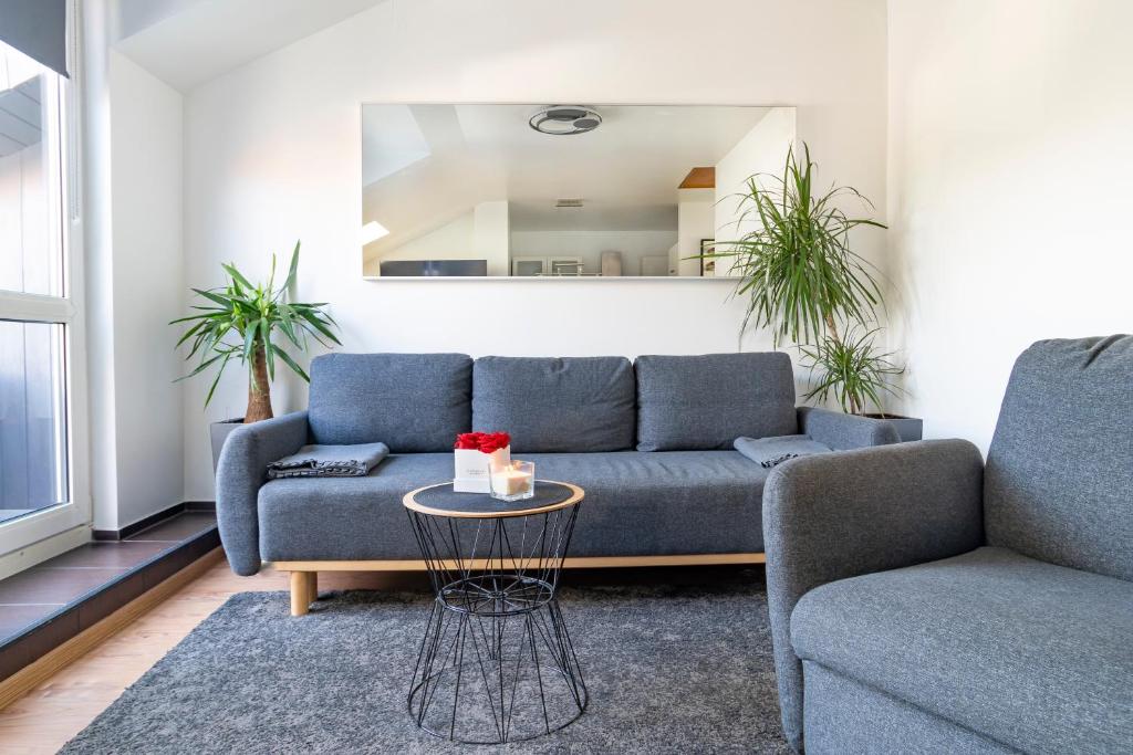 sala de estar con sofá azul y mesa en Stylish 2 Room Maisonette Hannover - Contactless Check-In, en Hannover