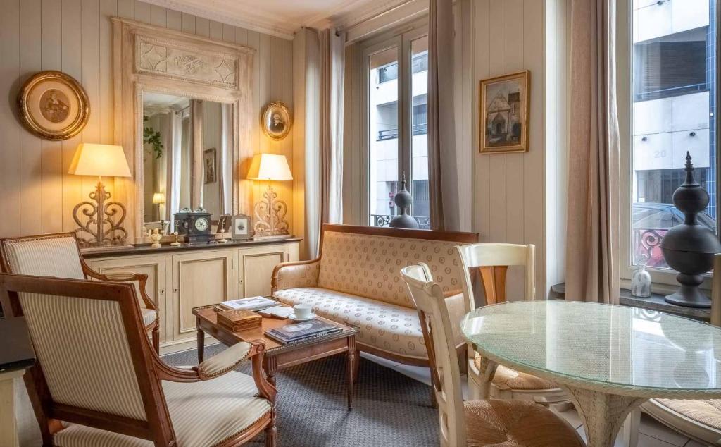 a living room filled with furniture and a table at Hôtel de l'Avre in Paris
