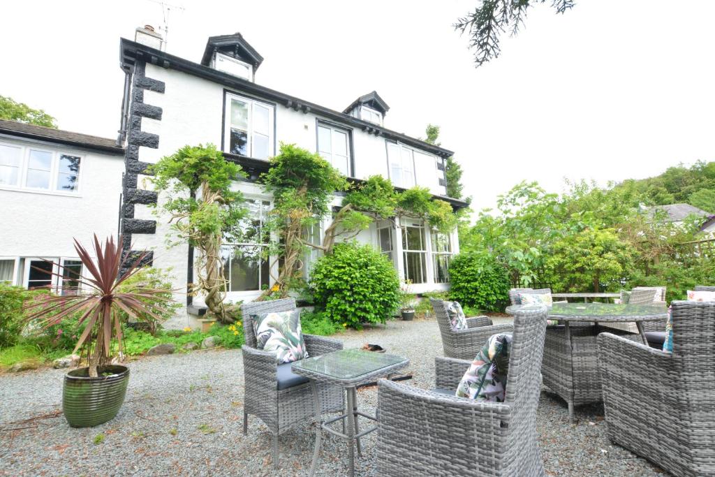 鲍内斯温德米尔Fairfield House and Gardens的房屋前设有椅子和桌子