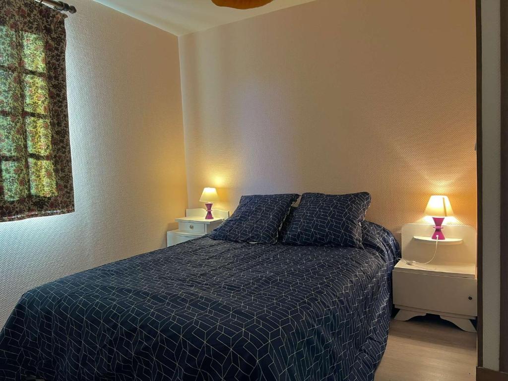 sypialnia z łóżkiem z niebieską kołdrą i 2 lampami w obiekcie Gîte Normand à 10mn d'Honfleur w mieście Genneville