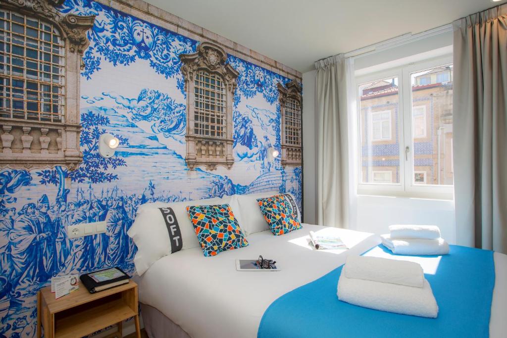 a bedroom with a bed with blue and white wallpaper at Casual Raízes Porto in Porto