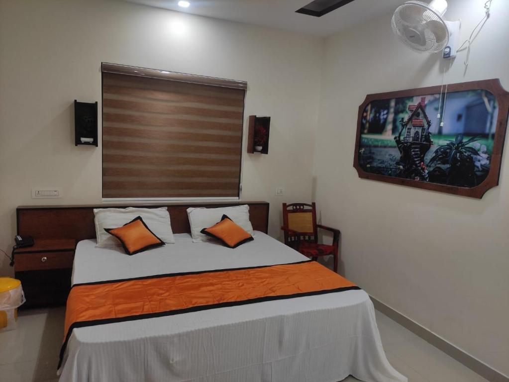 a bedroom with a bed and a tv on the wall at PMS Dhabi Residency in Kottakkal