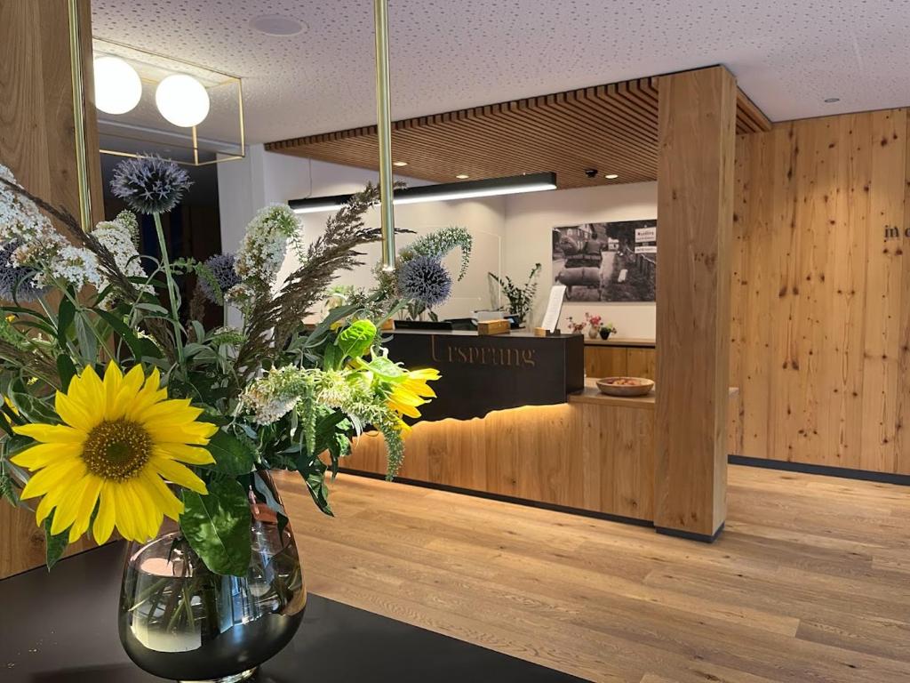 a vase of flowers on a table in a salon at Aparthotel Ursprung in Schladming