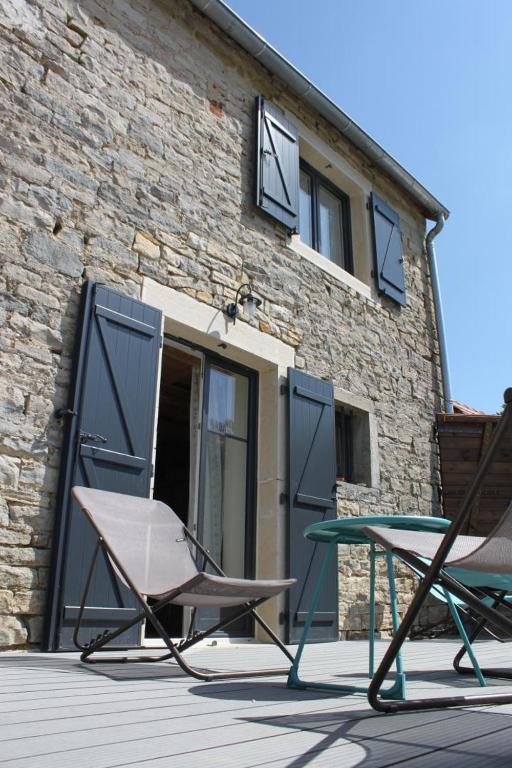 deux chaises et une table devant un bâtiment dans l'établissement La Maison au Comptoir, à Aiserey