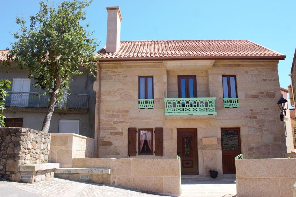 una antigua casa de piedra con balcón. en Casa de Miranda, en Ézaro