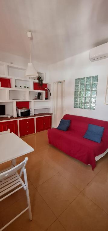 een kamer met een rood bed in een keuken bij Riverside Triana in Sevilla