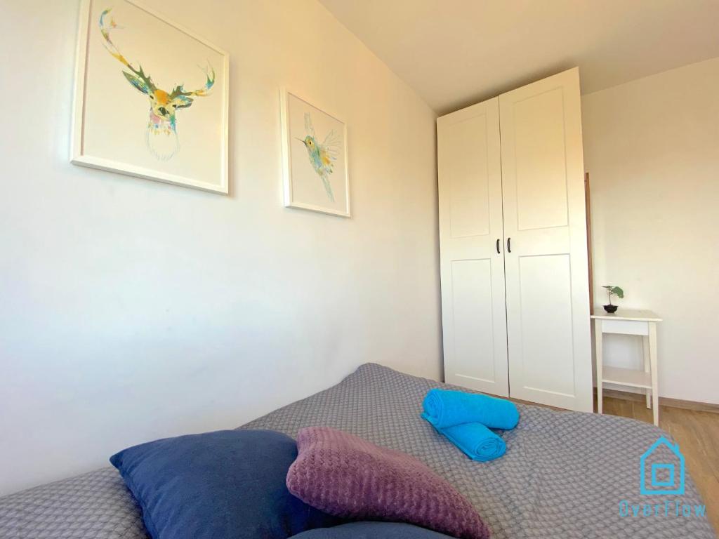 - une chambre avec un lit doté d'oreillers bleus et violets dans l'établissement Moose Room, à Gdańsk