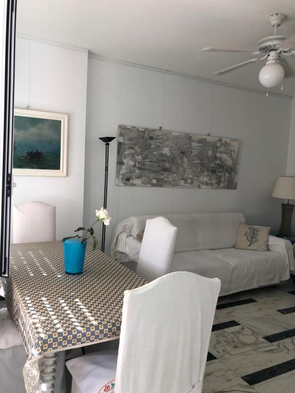 een woonkamer met een tafel en een bank bij Giusy near the sea in Sanremo