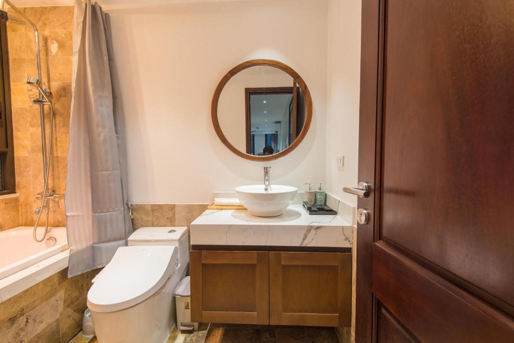 a bathroom with a toilet and a sink and a mirror at Sunny Home Apartment in Hanoi