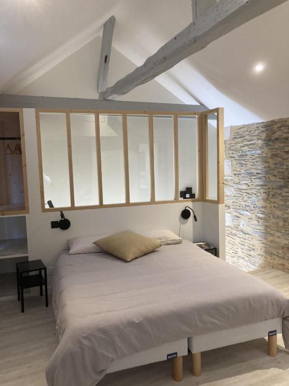 a bedroom with a large bed with white sheets at La Maison du Cocher - Chambre indépendante climatisée en Hypercentre - Lit Queen Size in Angers