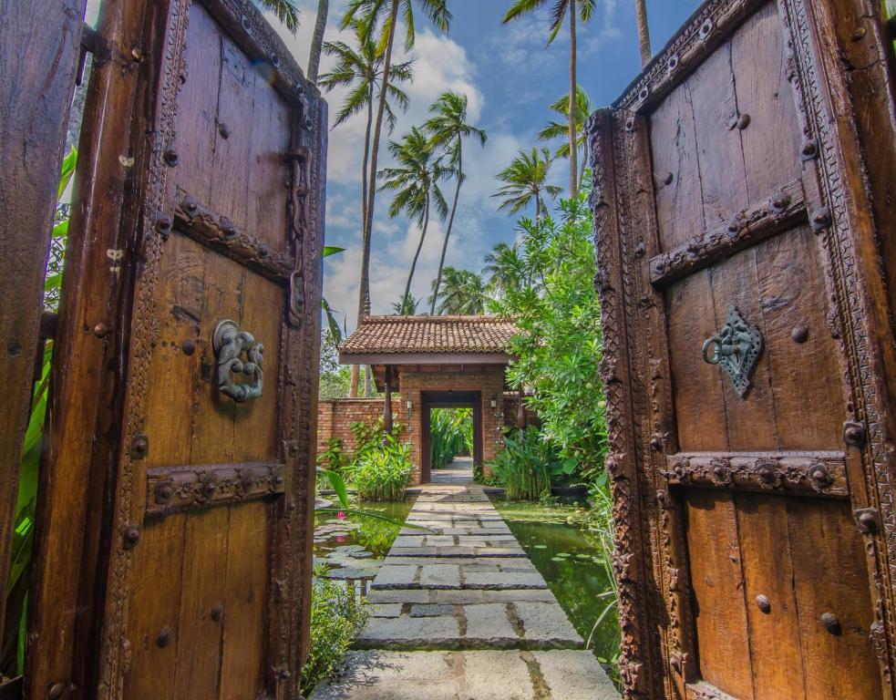 una entrada a una casa con 2 puertas de madera en Reef Villa, en Wadduwa