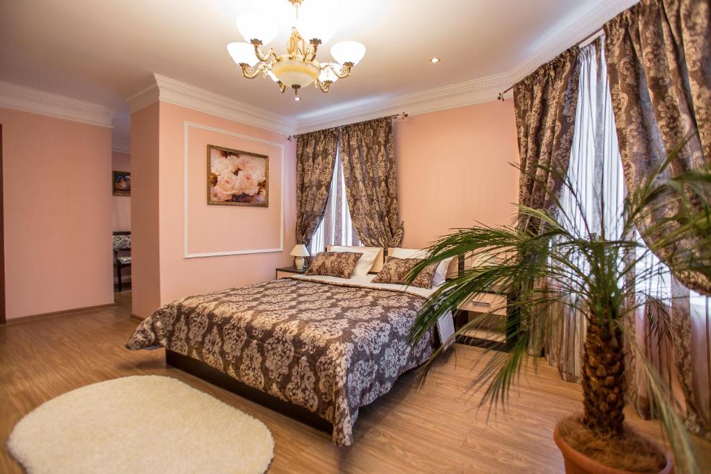 a bedroom with a bed and a potted plant at Hotel Benefit in Perm