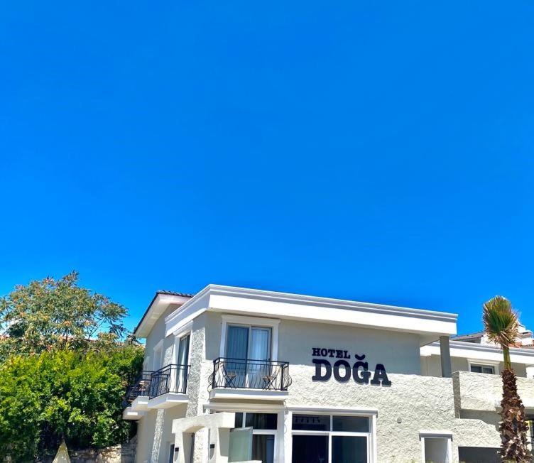 a white building with a doga sign on it at Hotel Doğa Çeşme in Çeşme