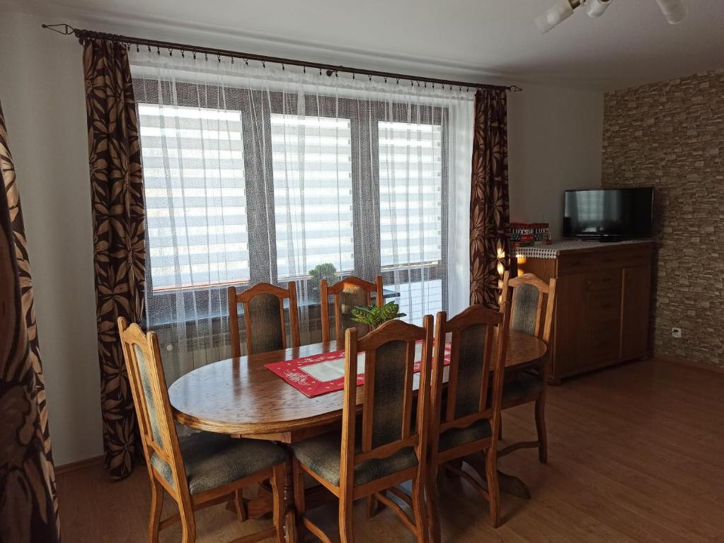 a dining room with a table and chairs and a window at Rodzinne Zacisze Bysina in Bysina