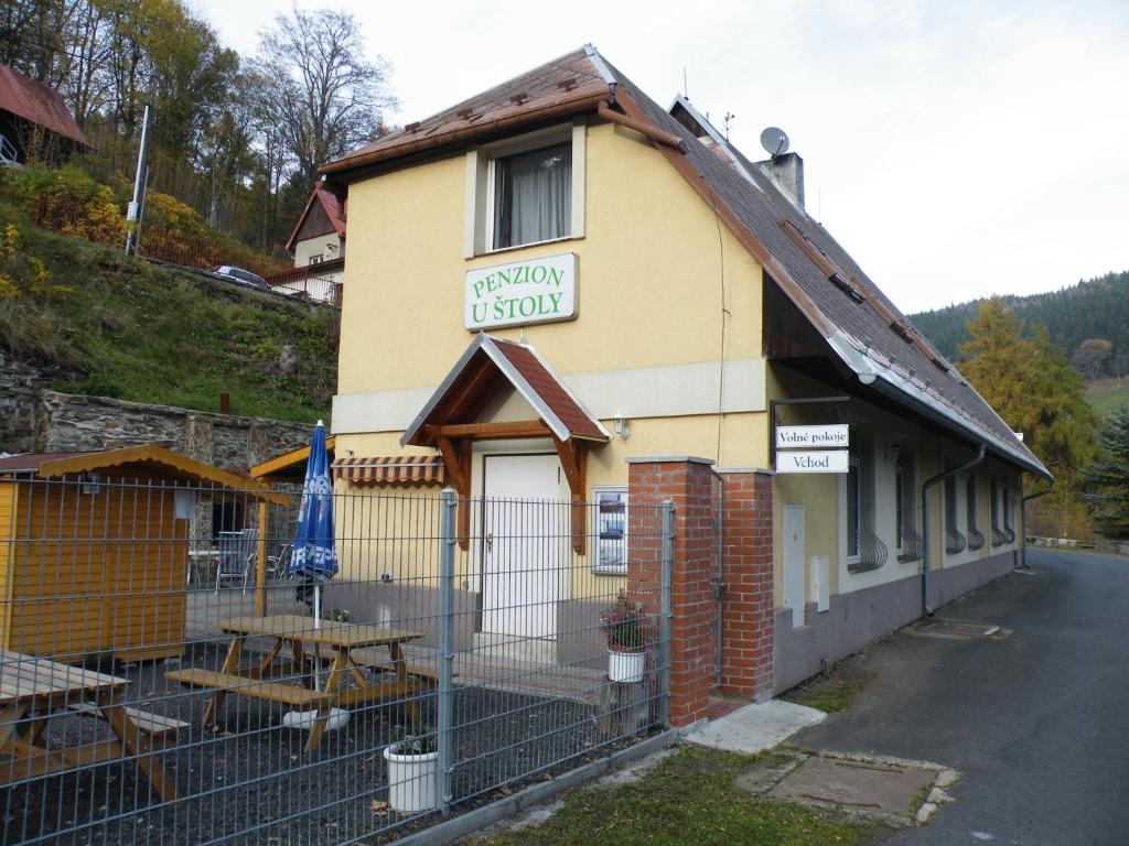 a small yellow building with a sign on it at Penzion U Štoly Jáchymov in Jáchymov