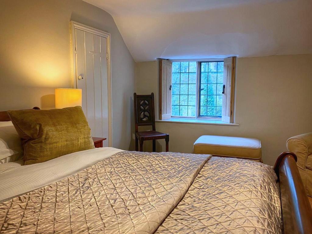 a bedroom with a large bed and a window at Baker's Cottage in Castle Combe