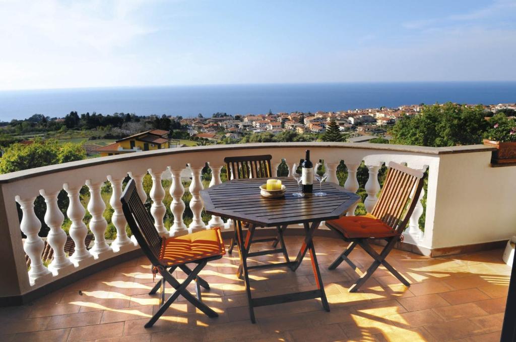 a patio with a table and chairs on a balcony at Villa Bella Vista in Santa Domenica