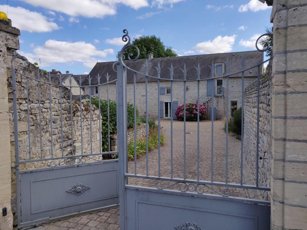 un cancello per un cortile con un edificio di Aux belles pierres a Carcagny
