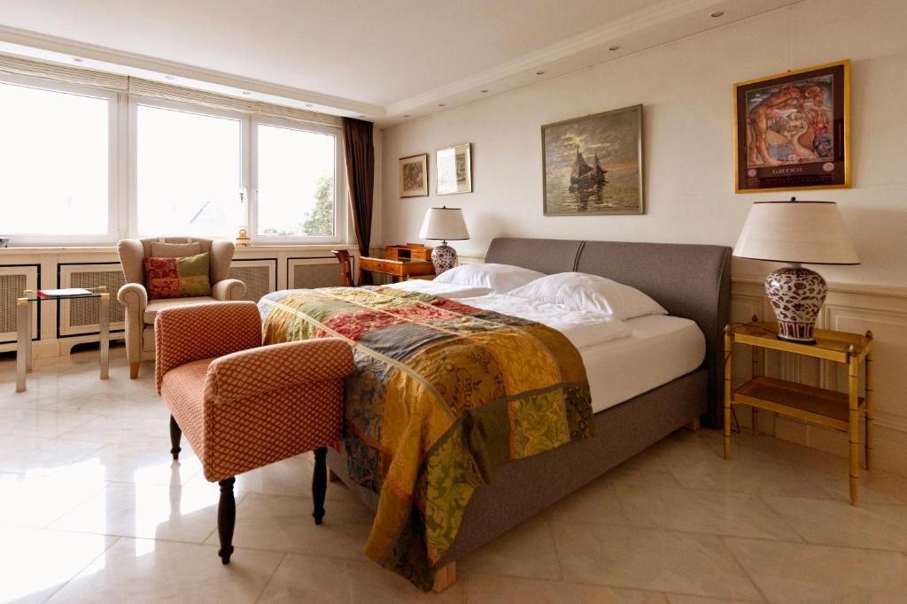 sypialnia z łóżkiem, krzesłem i oknami w obiekcie Die Villa Mettmann w mieście Mettmann
