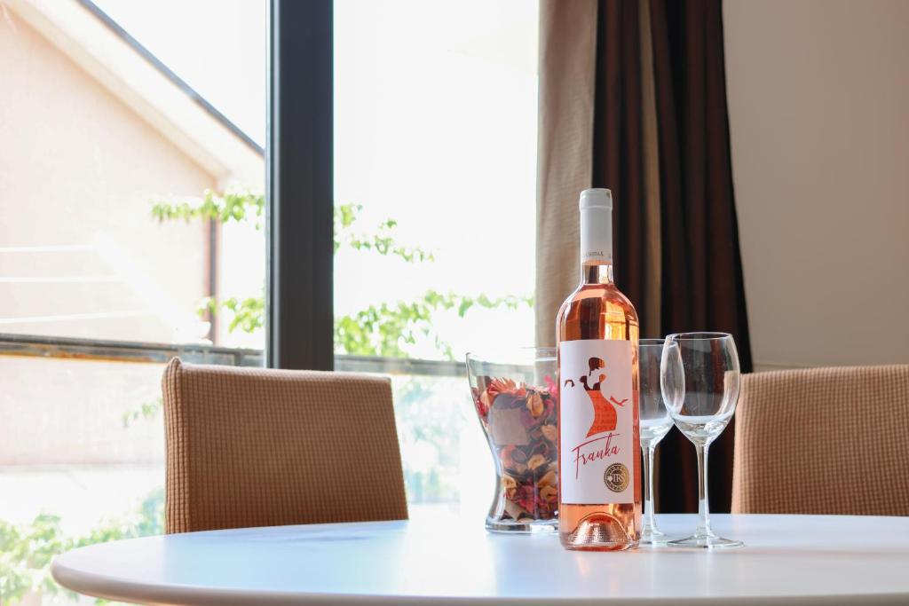 een fles wijn zittend op een tafel met twee glazen bij Apartman Pio - near the tram station and Lake Jarun in Zagreb