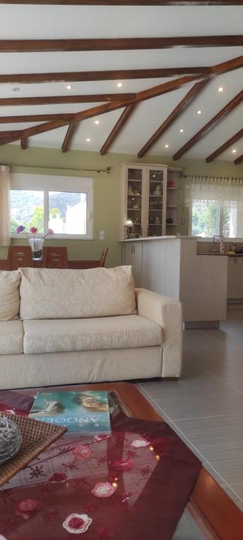 a living room with a white couch and a kitchen at KimonVilla in Porto Rafti