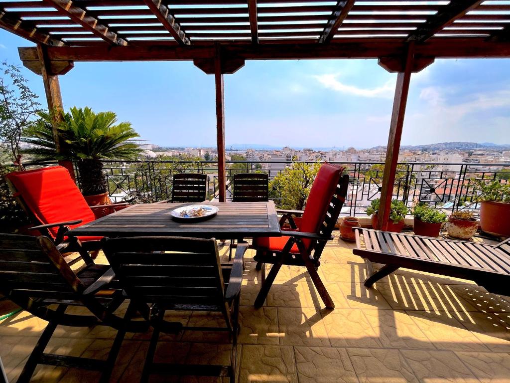 a table and chairs on a patio with a view at The Best Penthouse View near Stavros Niarchos Foundation in Athens
