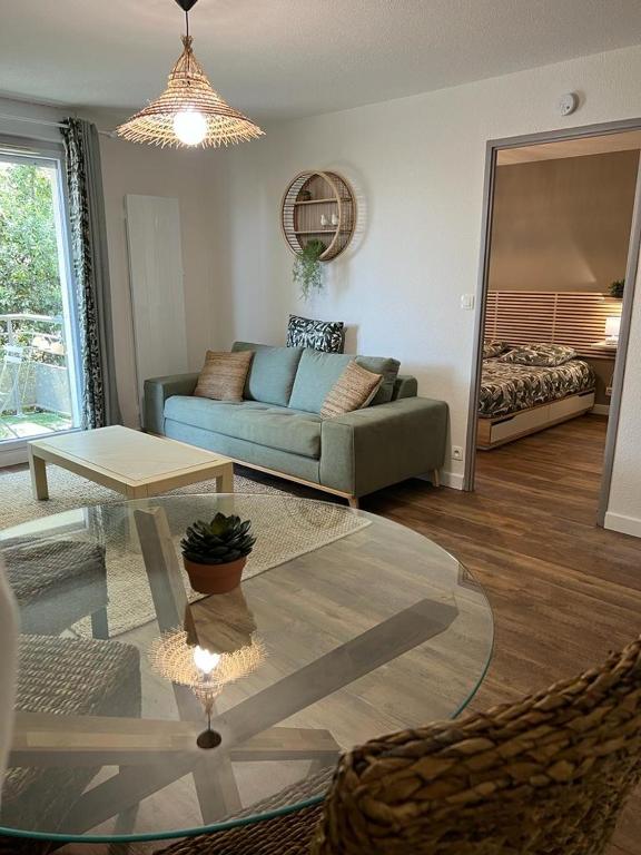 a living room with a couch and a table at Résidence Océane Appartement Nature in Albi