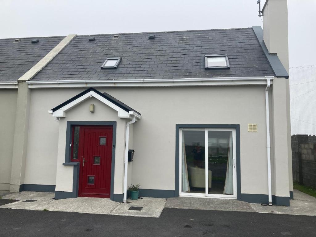 a white and red house with a red door at Cluain Uilinn in Miltown Malbay