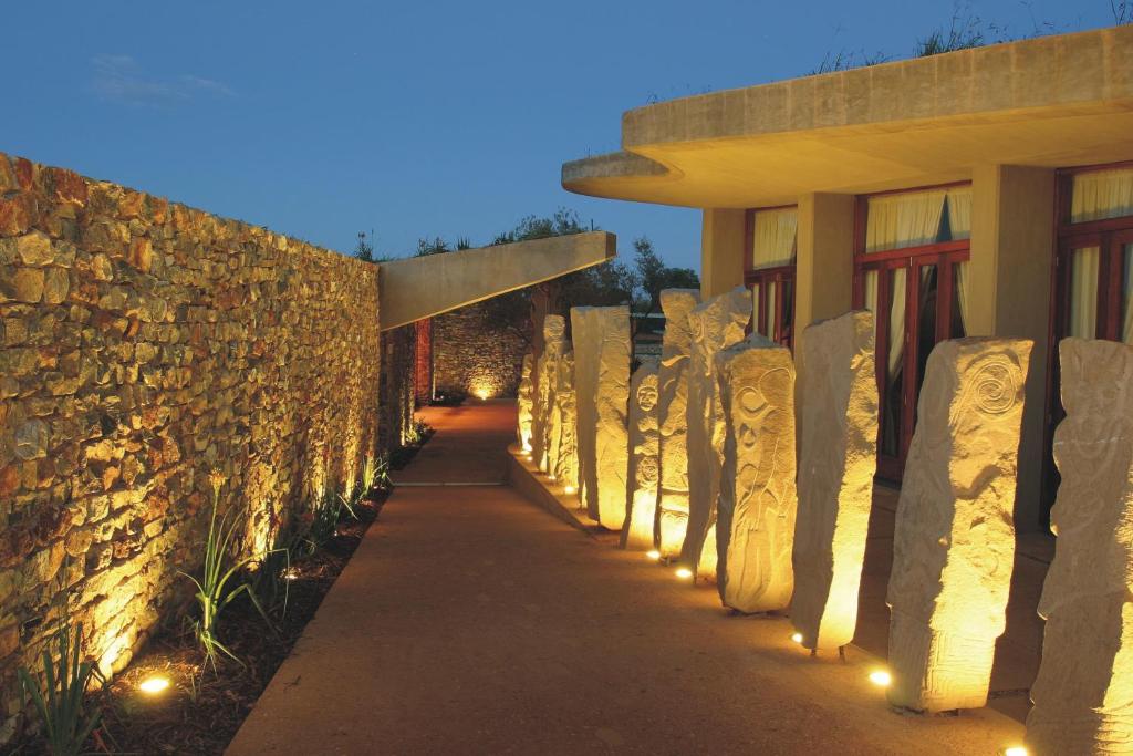 een stenen muur en een loopbrug naast een gebouw bij Forum Homini Boutique Hotel in Krugersdorp