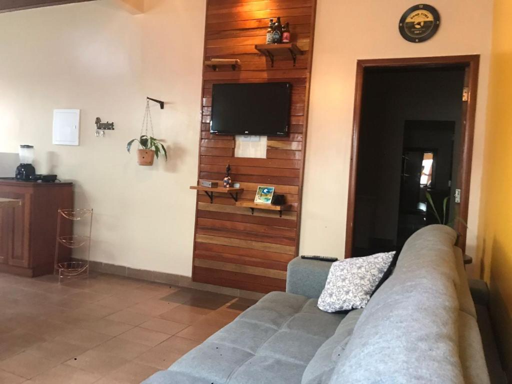 uma sala de estar com um sofá e uma televisão de ecrã plano em Casa LB com estacionamento privado em Boa Vista