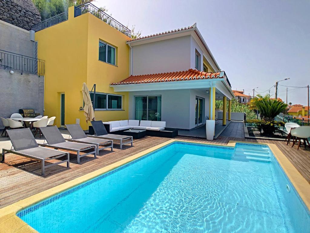 una villa con piscina di fronte a una casa di Estrela do Mar - by LovelyStay - Lovely, Sun Filled Villa a Calheta