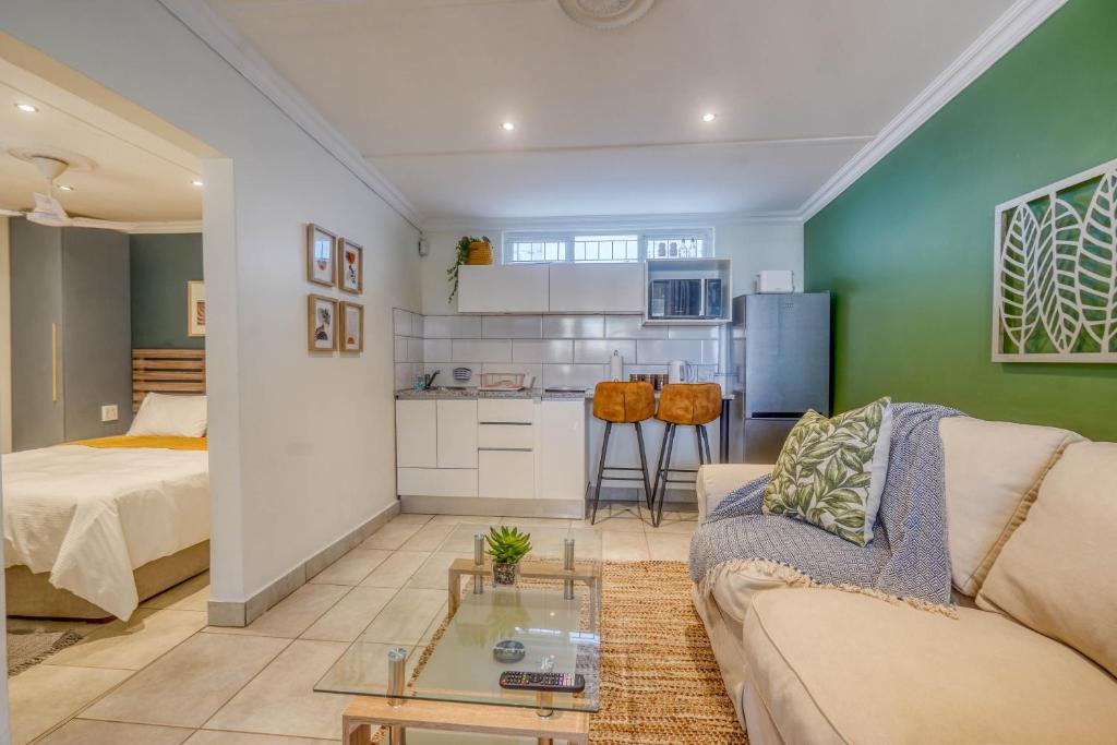 a living room with a couch and a table at Hampton Collection - Trendy 2 Sleeper Apartment with Pool in Durban