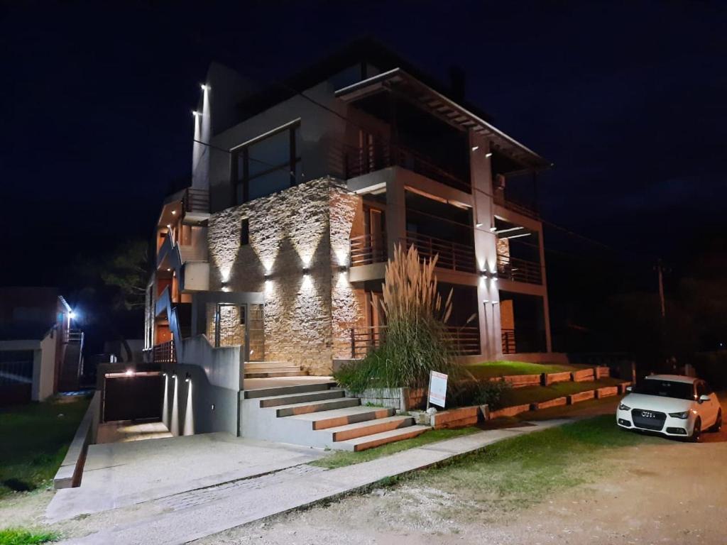 a house with a car parked in front of it at night at Arenas 1 in Valeria del Mar