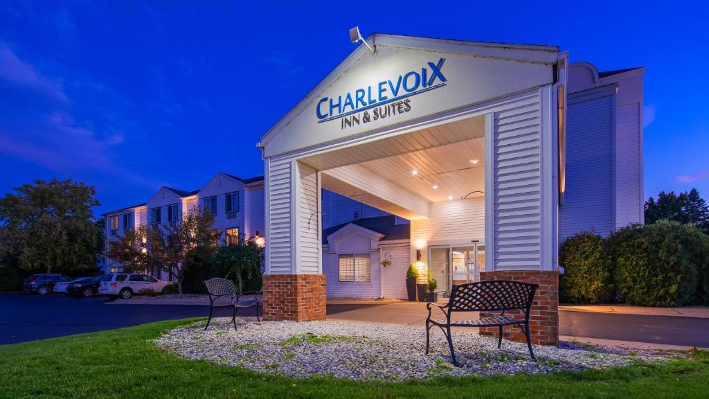 a building with a sign that reads chiasmok inn and suites at Charlevoix Inn & Suites SureStay Collection by Best Western in Charlevoix